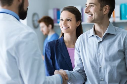 A happy couple meeting with a doctor after learning of their pregnancy with the help of our endocrinology specialist doctor in Idaho Falls or Pocatello.