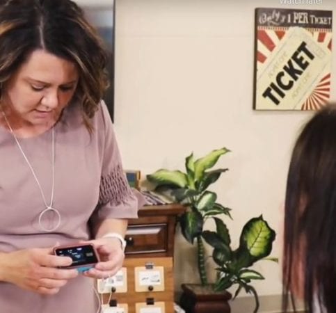 Diabetes Educator looking at medical equipment called a continuous glucose monitoring system or insulin pump.